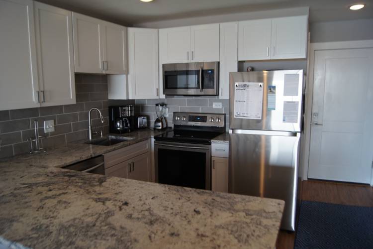 Kitchen with refrigerator, stove, microwave, toaster, coffee pot, dishwasher, and sink